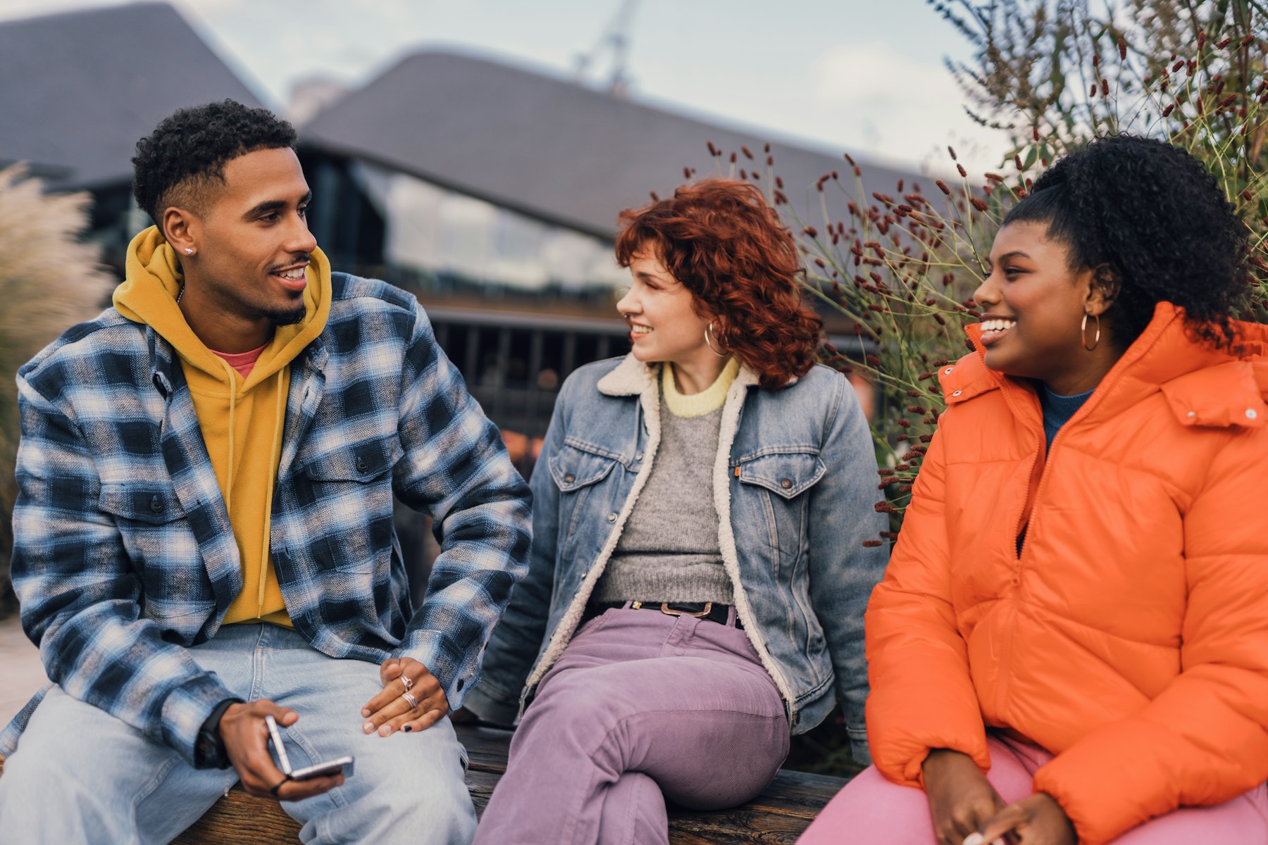 A group of people sitting and talking together outdoors