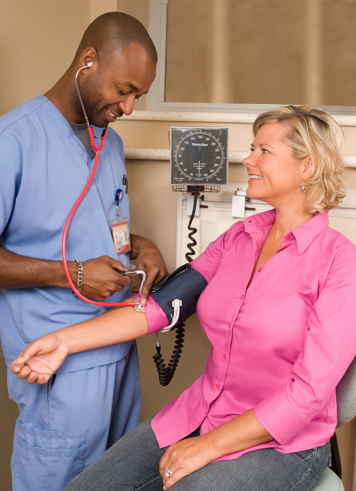 A healthcare worker checking a patient&rsquo;s blood pressure